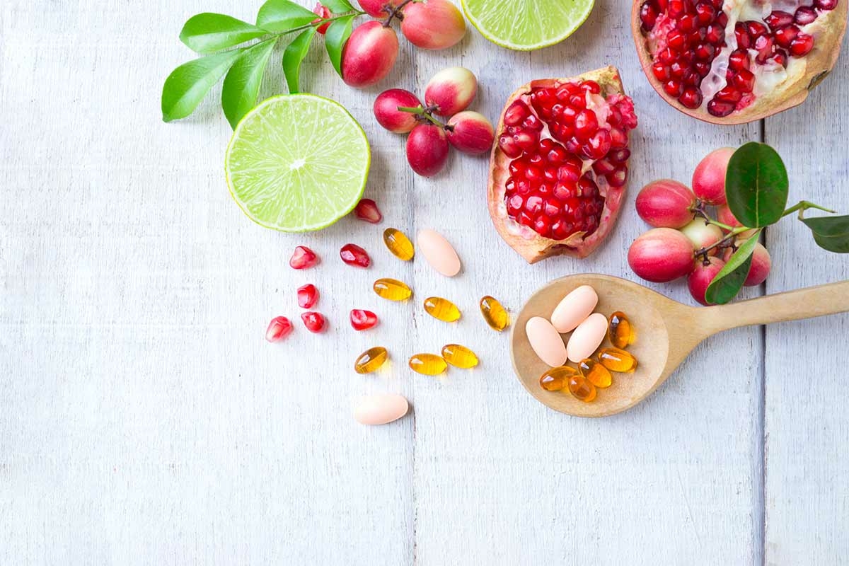 Fruits éparpillés et gélules de vitamines, pour soutenir l’organisme sans grossir
