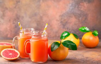 Pamplemousses et oranges coupés et jus d’agrumes sur une table