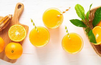 Fruits riches en vitamine c et jus d’oranges sur fond blanc